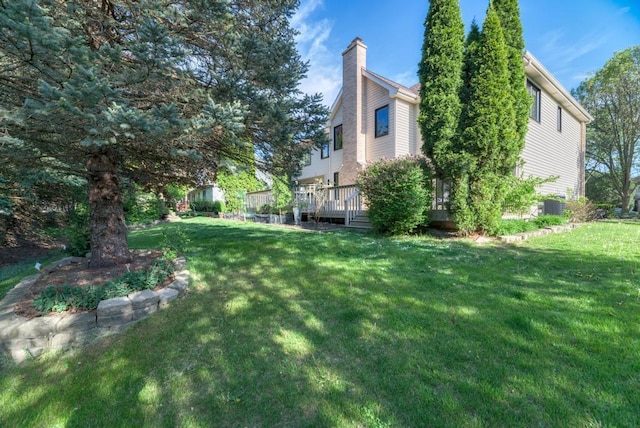 view of grassy yard featuring a wooden deck
