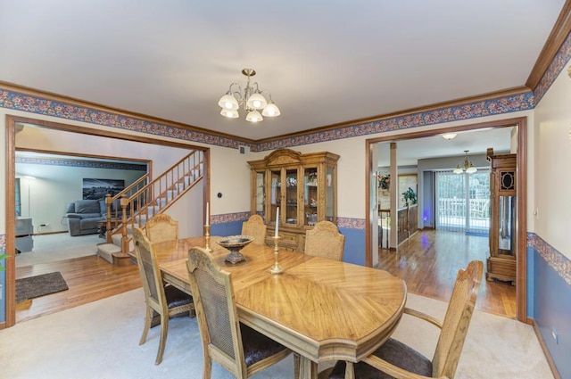dining room featuring a chandelier, light wood finished floors, stairway, and ornamental molding