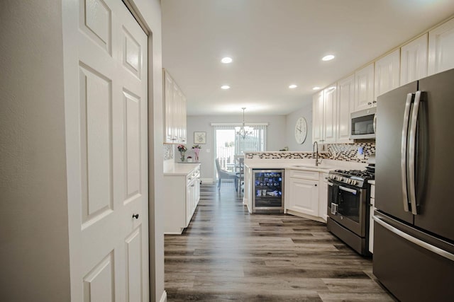 2650 Carlisle Ln, Hampshire, IL 60140 - kitchen with stainless steel appliances, beverage cooler, a chandelier, a sink, and white cabinets