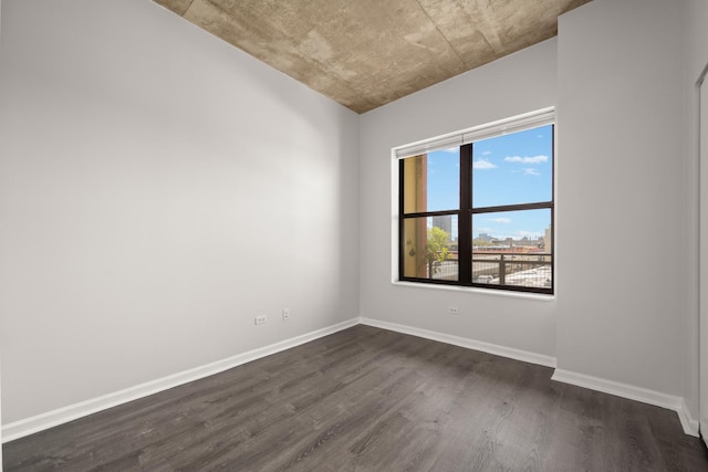 empty room featuring dark wood finished floors and baseboards