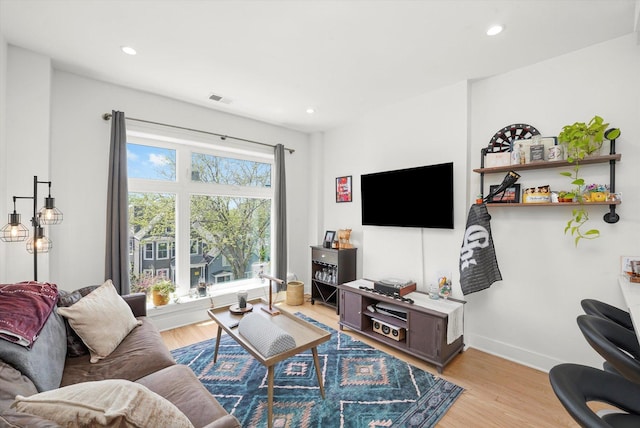 living area with light wood finished floors, recessed lighting, and baseboards