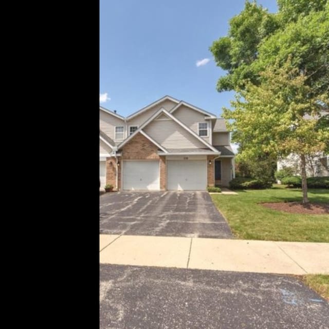 319 E Theodore Ln, Itasca, IL 60143 - view of front of property with driveway, brick siding, and a front yard