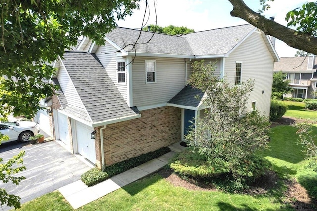 319 E Theodore Ln, Itasca, IL 60143 - view of property exterior with a garage, a shingled roof, brick siding, and driveway