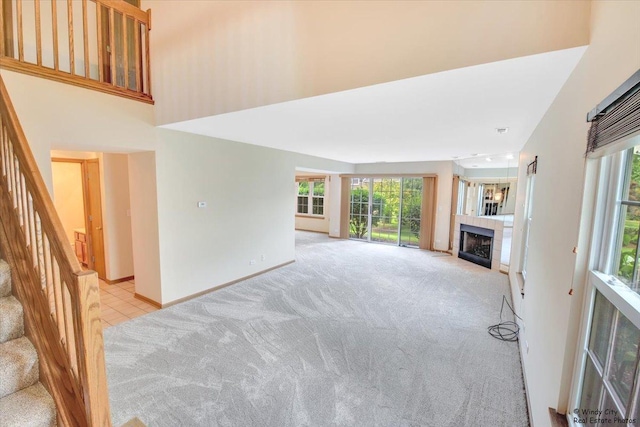 319 E Theodore Ln, Itasca, IL 60143 - unfurnished living room featuring light colored carpet, stairway, and a tiled fireplace