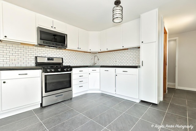 5305 N Highland Dr, Mchenry, IL 60050 - kitchen featuring stainless steel appliances, dark countertops, dark tile patterned flooring, backsplash, and a sink
