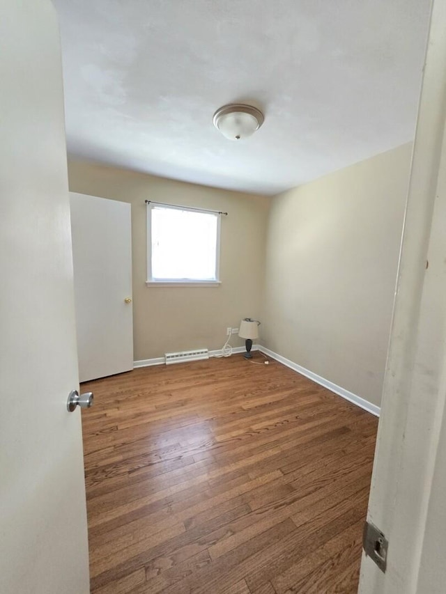 empty room with wood finished floors and baseboards