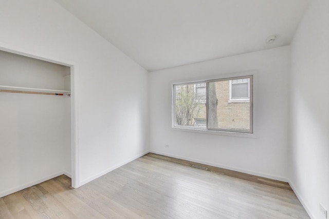 523 Green Bay Rd, Highland Park, IL 60035 - unfurnished bedroom featuring light wood-style flooring, baseboards, a closet, and lofted ceiling