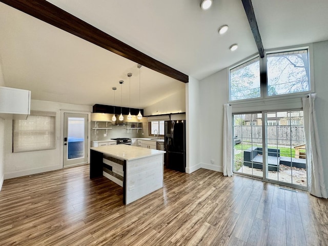 523 Green Bay Rd, Highland Park, IL 60035 - kitchen with black refrigerator with ice dispenser, beamed ceiling, light countertops, wood finished floors, and baseboards