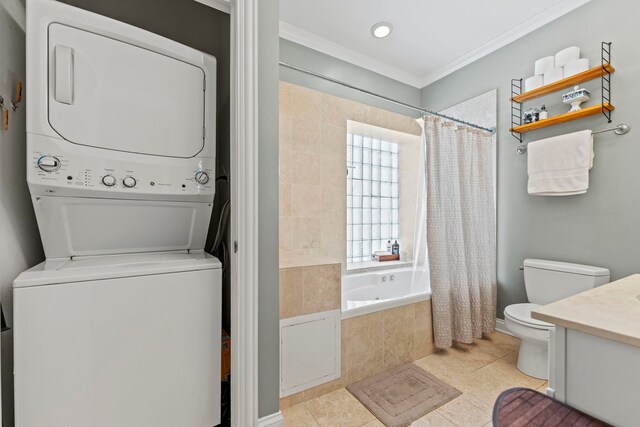 full bath with stacked washing machine and dryer, tile patterned flooring, toilet, crown molding, and tiled shower / bath