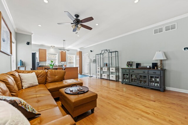 living area featuring a ceiling fan, light wood-type flooring, ornamental molding, baseboards, and recessed lighting