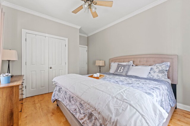 bedroom featuring crown molding, light wood-style flooring, a closet, and ceiling fan