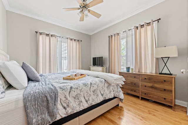 bedroom featuring wood finished floors, crown molding, baseboards, and ceiling fan