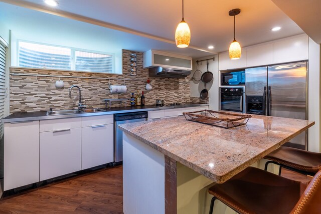4610 Main St, Lisle, IL 60532 - kitchen with appliances with stainless steel finishes, a sink, backsplash, under cabinet range hood, and dark wood-style floors