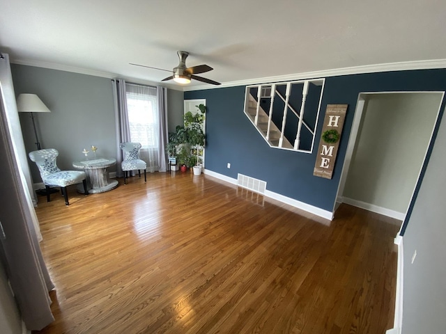 unfurnished room featuring stairway, ceiling fan, wood finished floors, crown molding, and baseboards