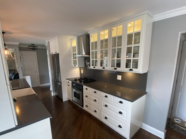 kitchen featuring wall chimney exhaust hood, stainless steel oven, dark countertops, black gas stovetop, and ornamental molding