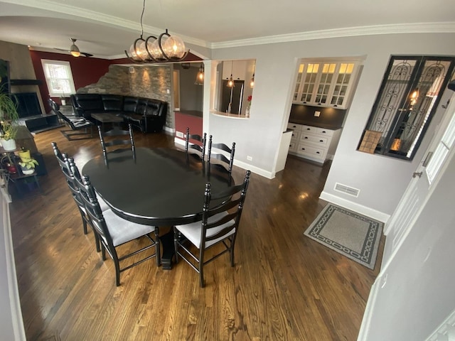 dining space featuring wood finished floors, ornamental molding, ceiling fan, and baseboards