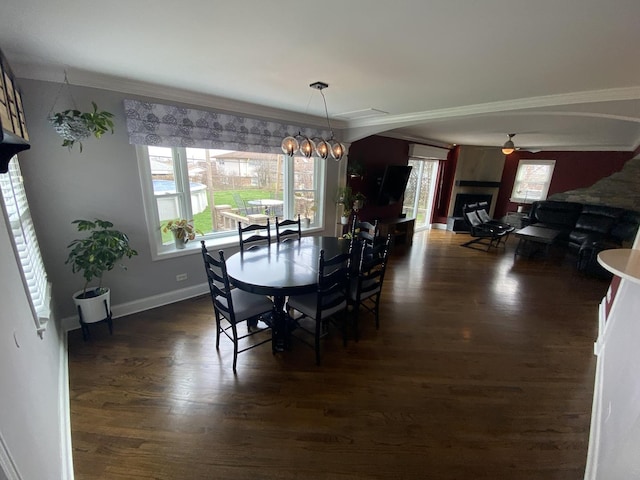 dining room with ornamental molding, dark wood-style floors, baseboards, and ceiling fan