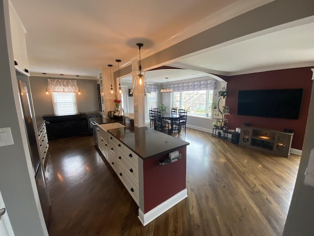 kitchen with dark countertops, a chandelier, white cabinetry, dark wood finished floors, and crown molding
