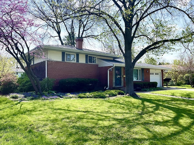 tri-level home with brick siding, a chimney, a garage, and a front yard