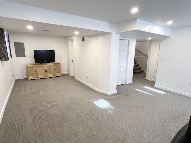 finished below grade area featuring carpet floors, baseboards, recessed lighting, stairs, and electric panel