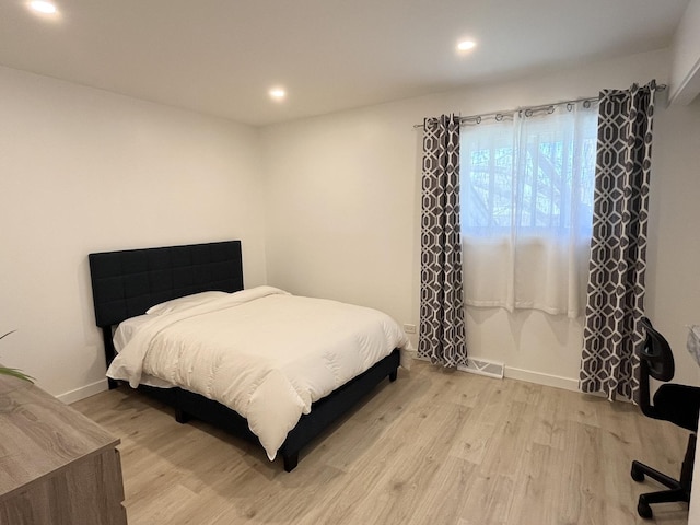bedroom featuring light wood finished floors, recessed lighting, and baseboards
