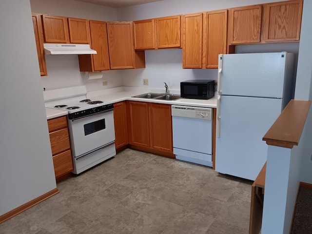 kitchen with white appliances, a sink, under cabinet range hood, light countertops, and brown cabinetry