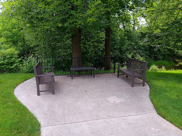 view of property's community featuring a yard and a patio