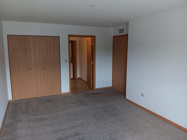 unfurnished bedroom featuring carpet, a closet, and baseboards