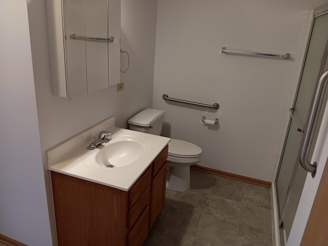 bathroom with a stall shower, toilet, vanity, and baseboards
