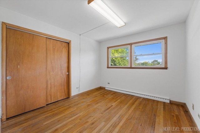 2663 Southcrest Dr, Downers Grove, IL 60516 - unfurnished bedroom with a baseboard heating unit, light wood finished floors, a closet, and baseboards