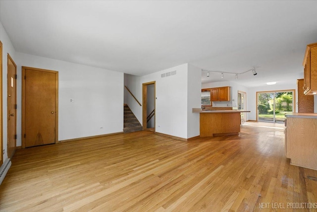 2663 Southcrest Dr, Downers Grove, IL 60516 - unfurnished living room with light wood-type flooring, stairs, rail lighting, baseboards, and a baseboard heating unit