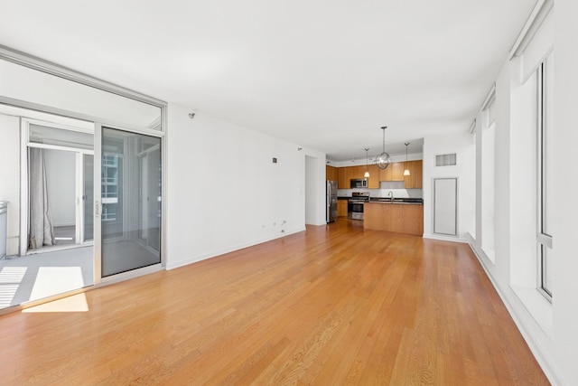 1250 S Michigan Ave Unit 1502, Chicago, IL 60605 - unfurnished living room featuring a chandelier, light wood finished floors, and a sink