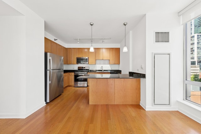 1250 S Michigan Ave Unit 1502, Chicago, IL 60605 - kitchen with stainless steel appliances, a sink, a peninsula, dark countertops, and light wood-style flooring