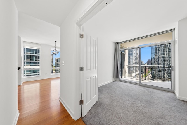 1250 S Michigan Ave Unit 1502, Chicago, IL 60605 - hallway featuring baseboards, wood finished floors, a chandelier, and a city view