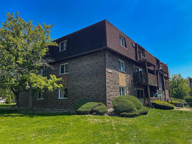 19360 Wolf Rd Unit 8, Mokena, IL 60448 - view of side of property featuring brick siding, mansard roof, a yard, and a balcony