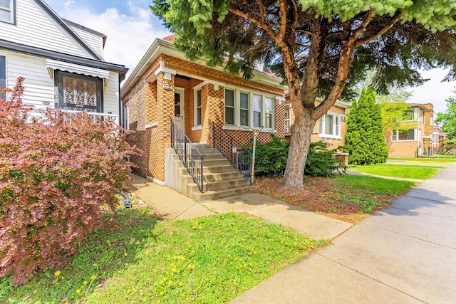 view of front of house featuring brick siding and a front lawn