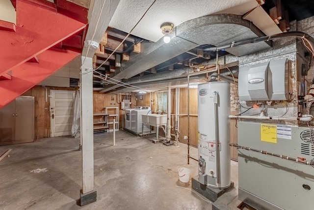 unfinished basement featuring gas water heater, washer and dryer, and heating unit