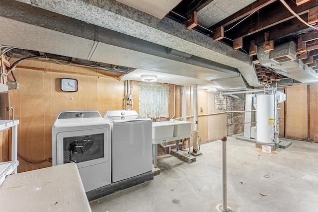 unfinished below grade area with water heater, independent washer and dryer, and a sink