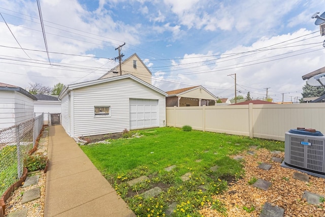view of yard featuring cooling unit, a detached garage, and an outbuilding