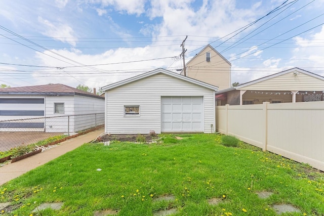 view of yard featuring a garage, an outdoor structure, and driveway