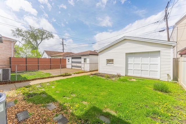 view of yard featuring a garage, an outbuilding, and central AC