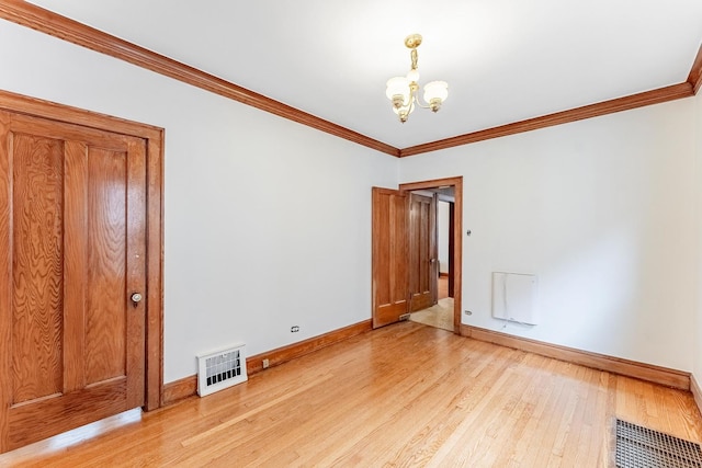 unfurnished room featuring crown molding, a chandelier, baseboards, and light wood-style flooring