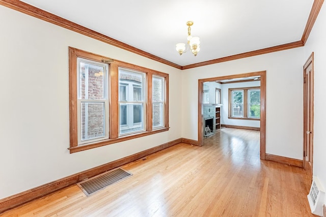 unfurnished dining area featuring a chandelier, light wood finished floors, baseboards, crown molding, and a fireplace with flush hearth