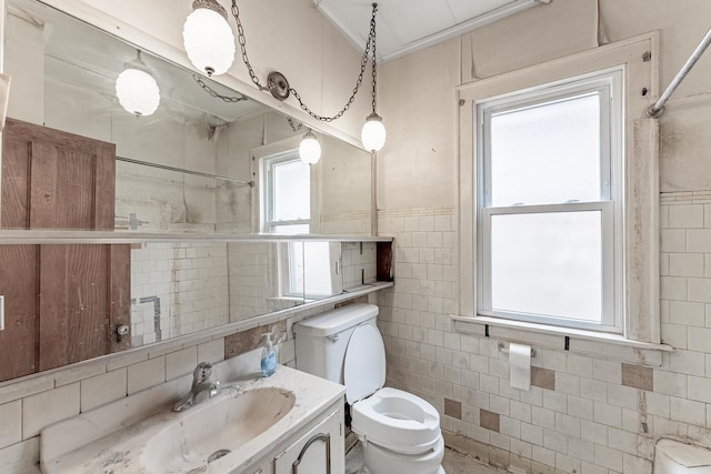 bathroom with tile walls, toilet, vanity, and crown molding