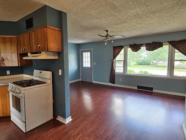 506 S 8th St, Oregon, IL 61061 - kitchen with white gas stove, under cabinet range hood, a textured ceiling, brown cabinetry, and a ceiling fan
