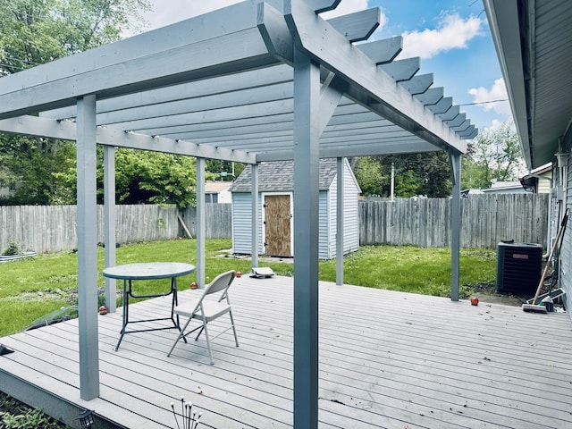 deck with a pergola, a storage shed, central AC, and an outbuilding