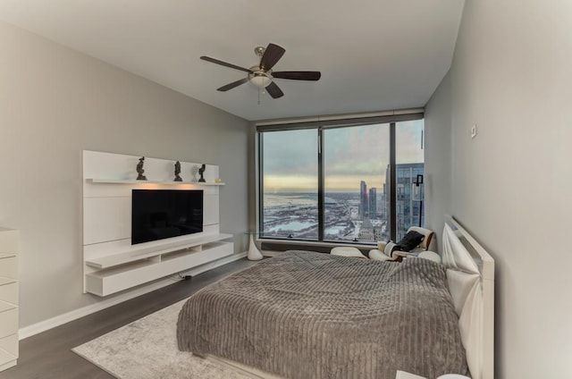 bedroom featuring wood finished floors, a wall of windows, baseboards, and ceiling fan