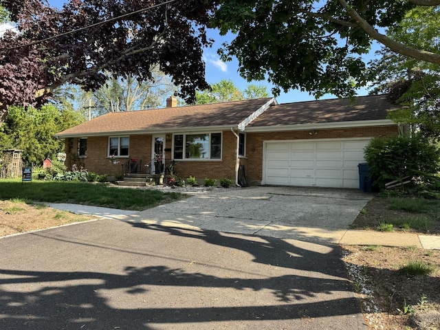 ranch-style house with an attached garage, brick siding, concrete driveway, and a chimney