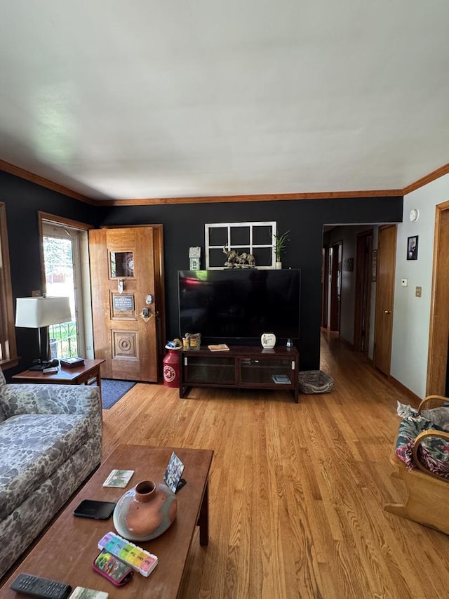 living area featuring light wood-type flooring and ornamental molding