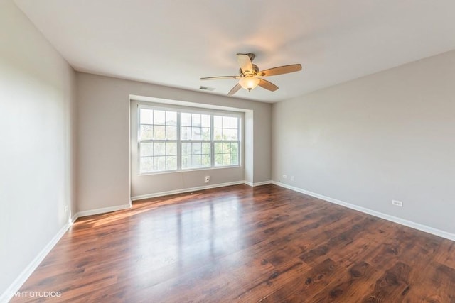 spare room with ceiling fan, wood finished floors, and baseboards